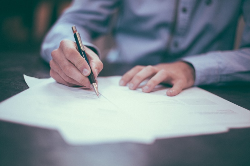 man signing a contract